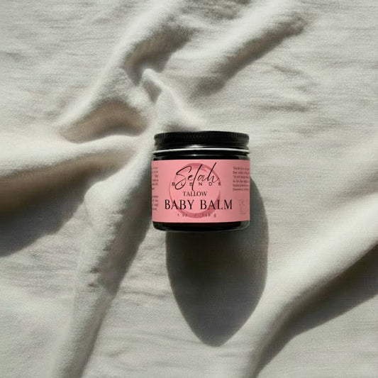 Pink baby balm jar on a light fabric background