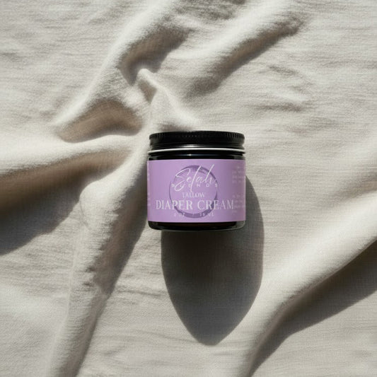 Purple jar of diaper cream on a textured beige surface