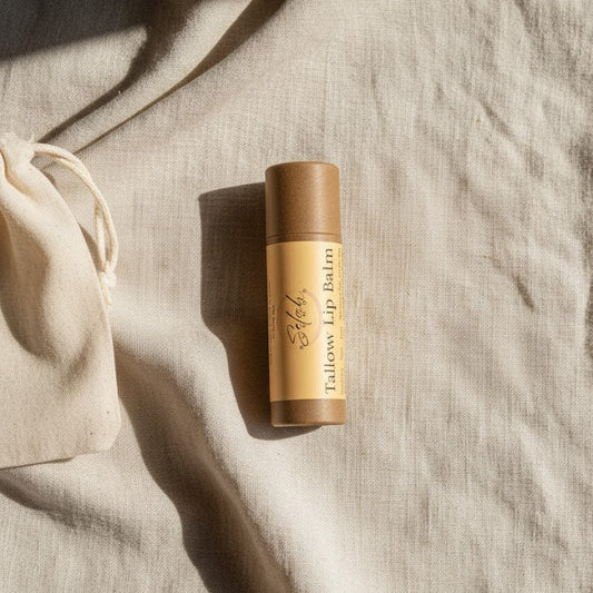 Lip balm on a textured beige surface with a drawstring bag